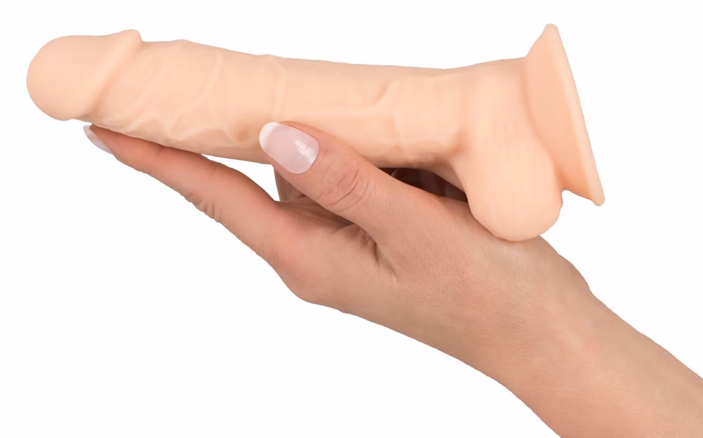 En hånd holder en dildo med pung