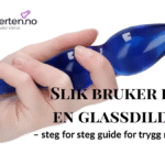 Glassdildo med strukturert overflate, presentert på lys bakgrunn.