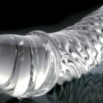 Glassdildo med strukturert overflate, elegant presentert på nøytral bakgrunn