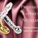 Tre dildoer i gull, glass og metall mot rosa sateng, med teksten «Presisjon. Fasthet. Nytelse.» – symboliserer luksus og intens, kontrollert stimulering.